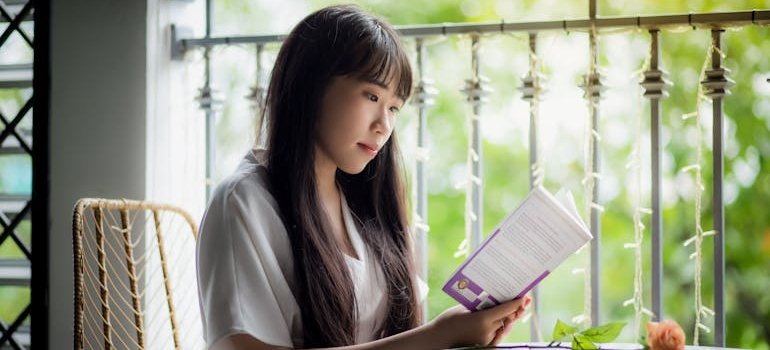 Woman sitting in a cafe and reading one of the best books to read in recovery.