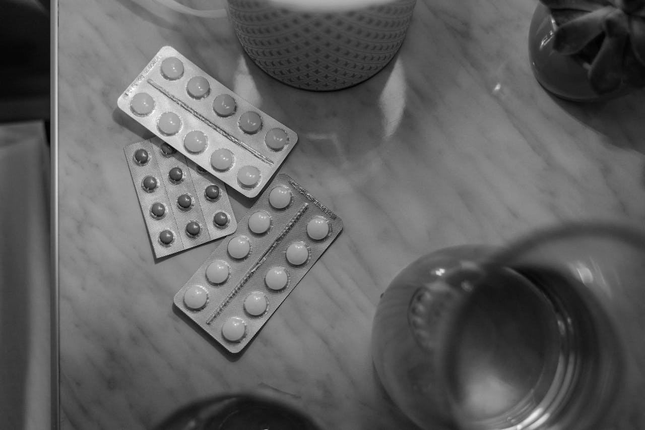 Black and white picture of pill blisters on a table.