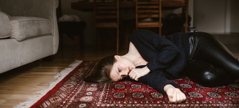 Woman lying on the floor and crying because of her issues with situational depression.