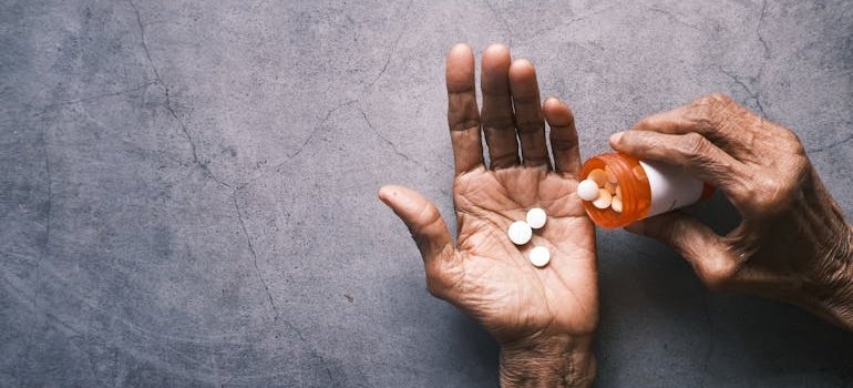 Older person pouring pills into their hand.